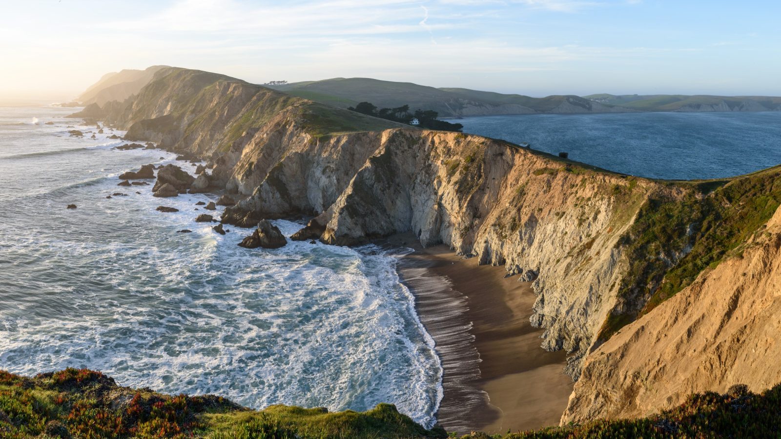 A wide view of protected ridge, farmland, and coastline representing Greenbelt's connected preserve network